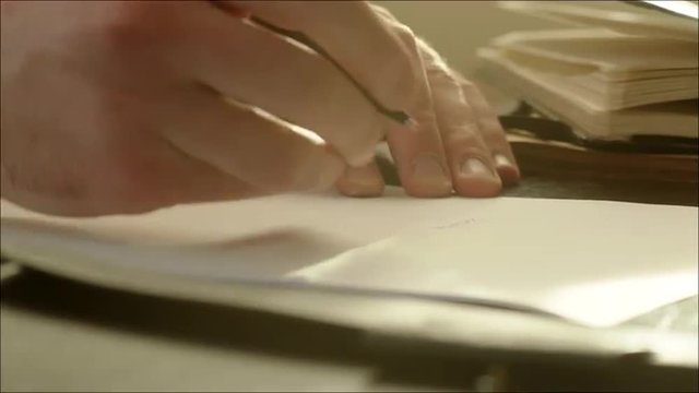 Man Writing on the Paper with Pen