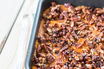 Homemade Mashed Sweet Potato Casserole with Caramelized Pecans on Light White Wooden Background, Christmas, Close-up