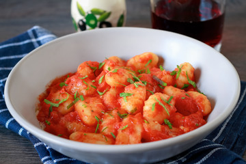 Homemade italian gnocchi with tomato sauce on a table