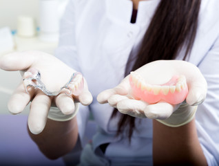 beautiful asian young woman dentist holding dentures
