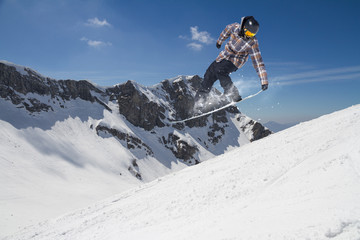 Flying snowboarder on mountains. Extreme sport.