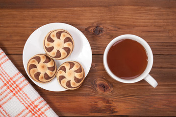 Delicious cookies and a cup of tea on a wooden background. Top view .