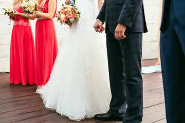 Fototapeta na wymiar bride with wedding bouquet hold groom hand on wedding ceremony