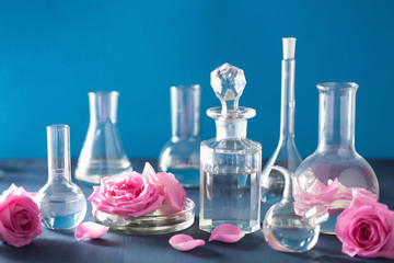 alchemy and aromatherapy with rose flowers and chemical flasks