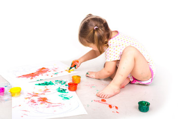 Happy baby girl with her hands in paint drawing