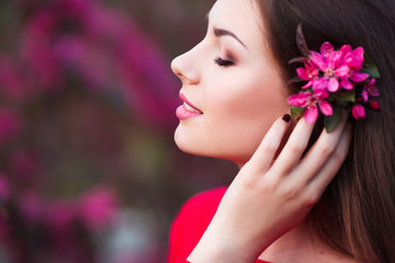 Happy beautiful young woman in spring blossom park. 