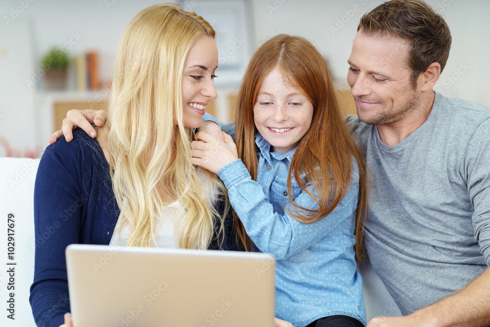 Wall mural eltern und tochter schauen gemeinsam auf den laptop