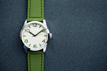 closeup automatic men watch with green wrist on dark background 