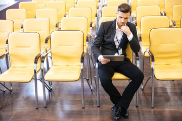 Businessman working with tablet in conference hall