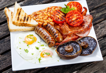 Full English breakfast with bacon, sausage, egg, beans and mushrooms