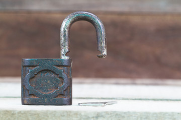 Old rusty grunge unlocked  key on  wooden background