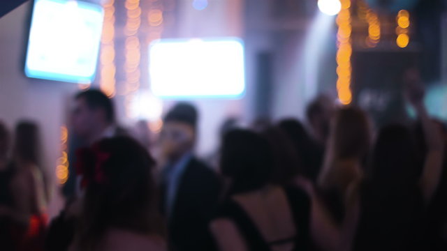 Blurred footage of crowded hall at night club with dancing young people around  students hanging out at their prom night, young people are celebrating wedding.