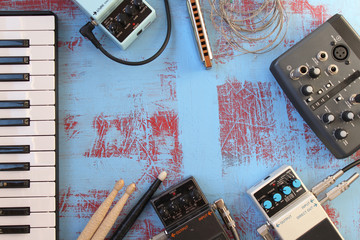 Music concept border design - guitar pedal, harmonica, piano key, audio card, audio plug and drum stick - copy space
