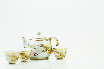 Vintage grunge chinese teapot set with golden dragons on white b