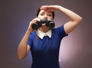Girl in a blue suit. Keep a binoculars in her hands. Makes gestu