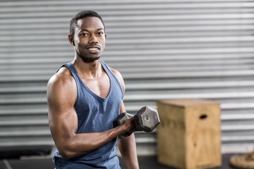 Naklejka premium Portrait of fit man lifting dumbbells