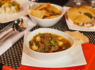 Mexican food. Soup on the table  with nachos and quesadilla on background.