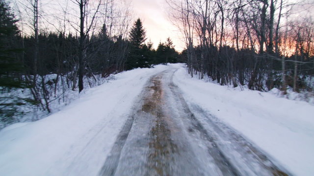 Suction Cut View from a Car Driving on a Small Off Road Path during a Winter Sunset