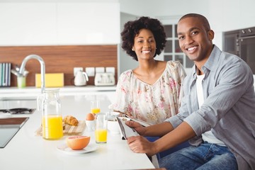 Smiling couple eating breakfast together in the kitchen