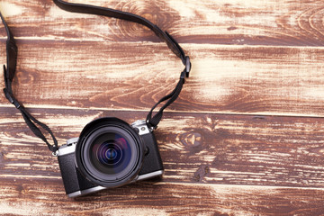 Digital camera with retro style on aged wooden background