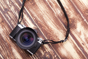 Digital camera with retro style on aged wooden background