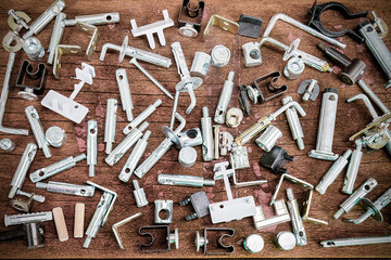 Mixed old small construction spare parts on vintage grunge wooden background