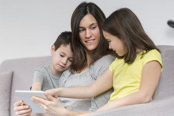 Smiling mother and children using tablet