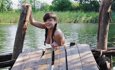 Young female mermaid on the wooden bridge