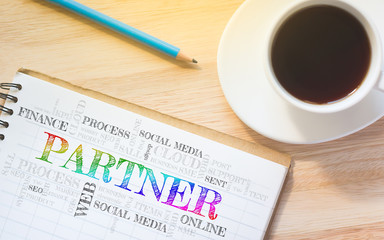 Concept PARTNER message on book. A pencil and a glass coffee table.Vintage tone.