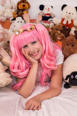 young girl in a bedroom in a pink cute dress