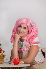 young girl with a pink wig creating origami