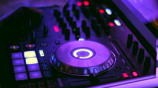 DJ Spinning, Mixing, and Scratching at a Night Club