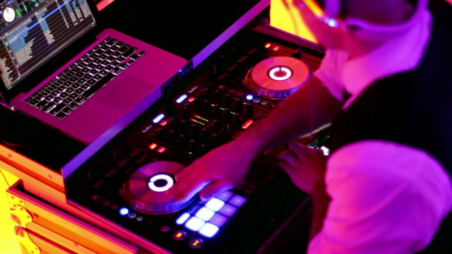 DJ Spinning, Mixing, and Scratching at a Night Club