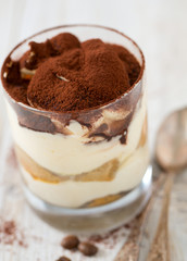 tiramisu in glass on wooden surface