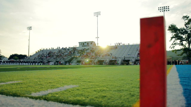 Unidentified High school football stadium filling up before a game.