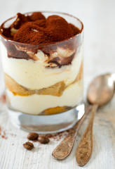 tiramisu in glass on wooden surface