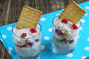 Morning muesli with yogurt and dried berries in glass jar.