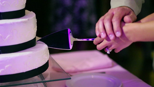 Close up of bride and groom cutting the wedding cake.