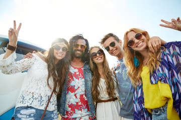 Fototapeta premium hippie friends over minivan car showing peace sign