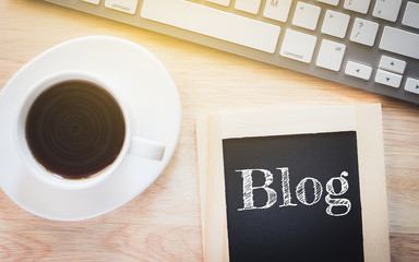 Concept Blog message on wood boards. A keyboard and a glass coffee table.Vintage tone.