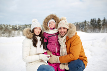 happy family with child in winter clothes outdoors