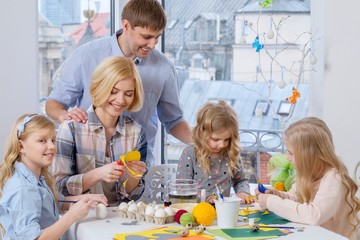 Cheerful family having fun painting and decorating easter eggs.