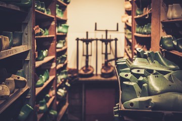 Various of vintage wooden shoe lasts in a row on the old shelves.