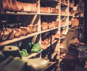 Various of vintage wooden shoe lasts in a row on the old shelves.