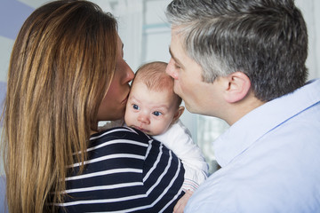 Proud Parents Holding Baby in the bedroom