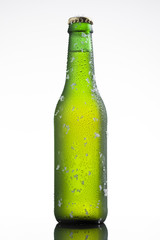 Bottle of ice cold beer with ice and drops