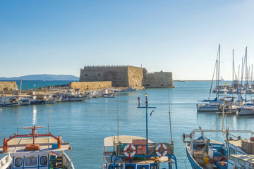 Fishing boats and Venetian Fortress in Heraklion harbor. Crete,