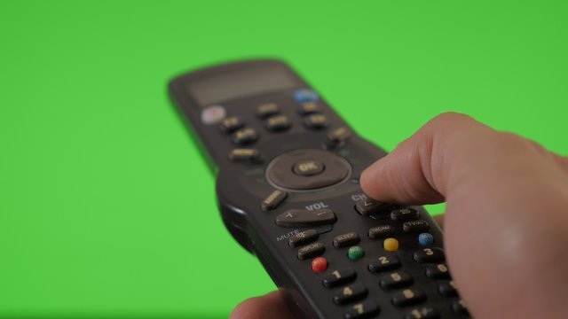 Channel changing with remote on green screen chroma background 4K 2160p UHD footage - Remote gestures on greenscreen background 4K 3840X2160 UHD video 
