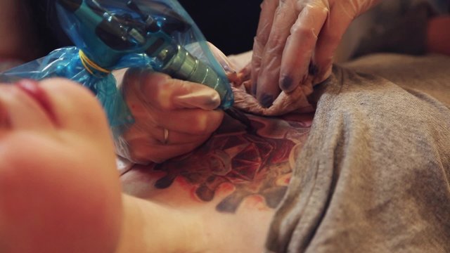 Cinemagraph loop - young girl lying on the couch during a session tattoos closeup - motion photo
