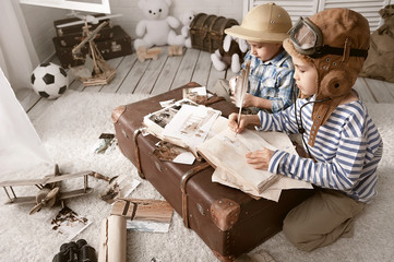 Boys in images traveler and pilot play in his room